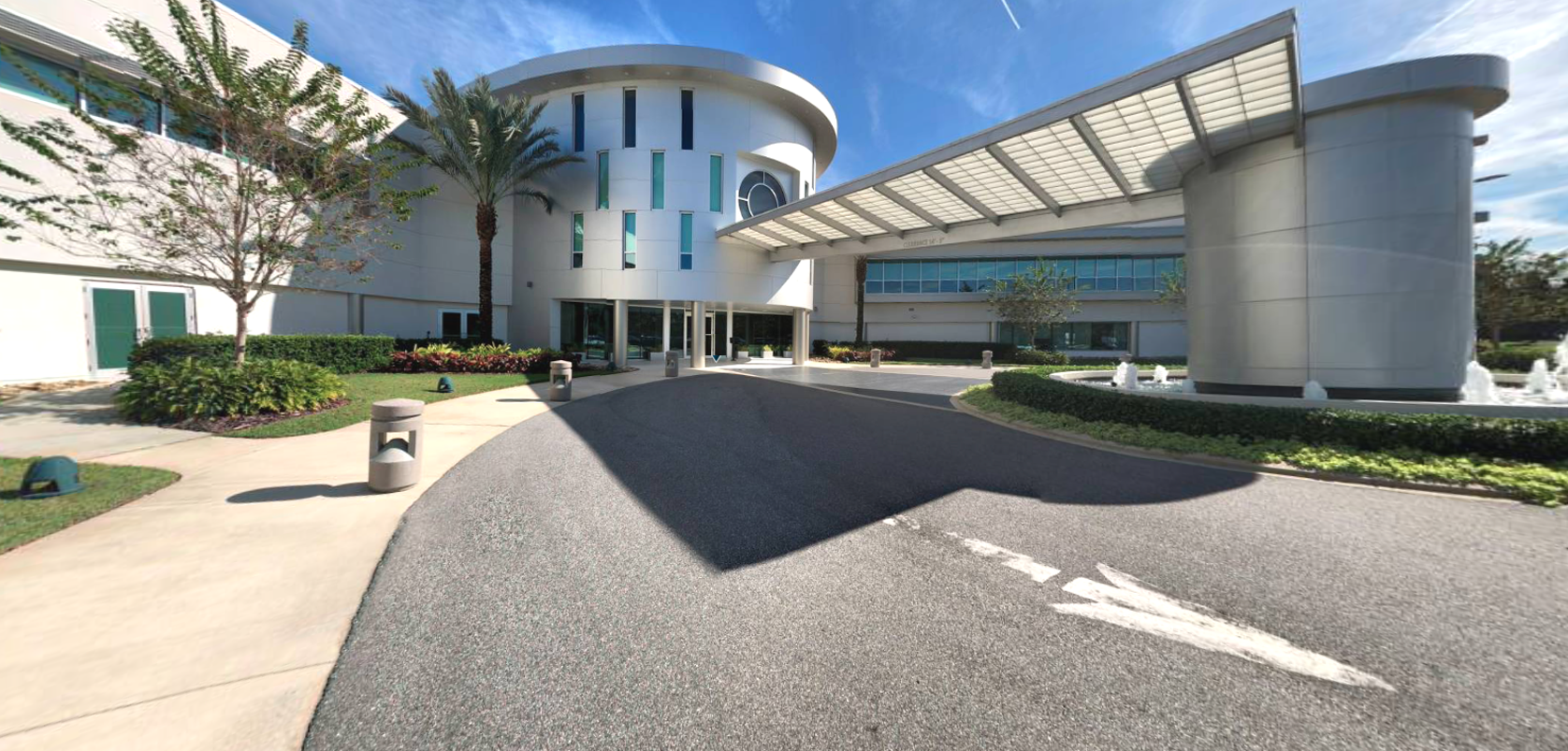 Satcom Direct World Headquarters in Melbourne FLorida. Palm trees and grey metalic looking building.