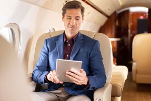 Satcom Direct interior of Gulfstream airplane with man on iPad running SD Pro