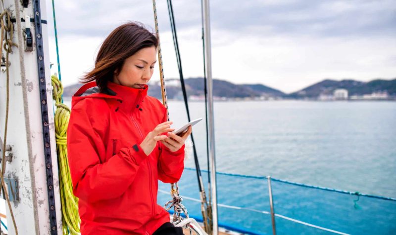 Woman on a luxury yacht looking at a smartphone. Okayama, Japan. March 2016
